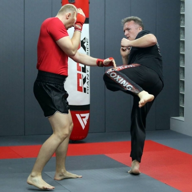 Trening do następnego egzaminu na stopnie kickboxingu pod okiem trenera personalnego